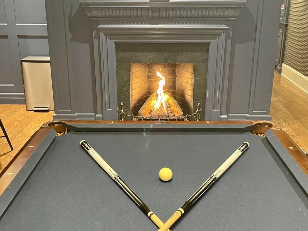 Fireplace beside a billiards table