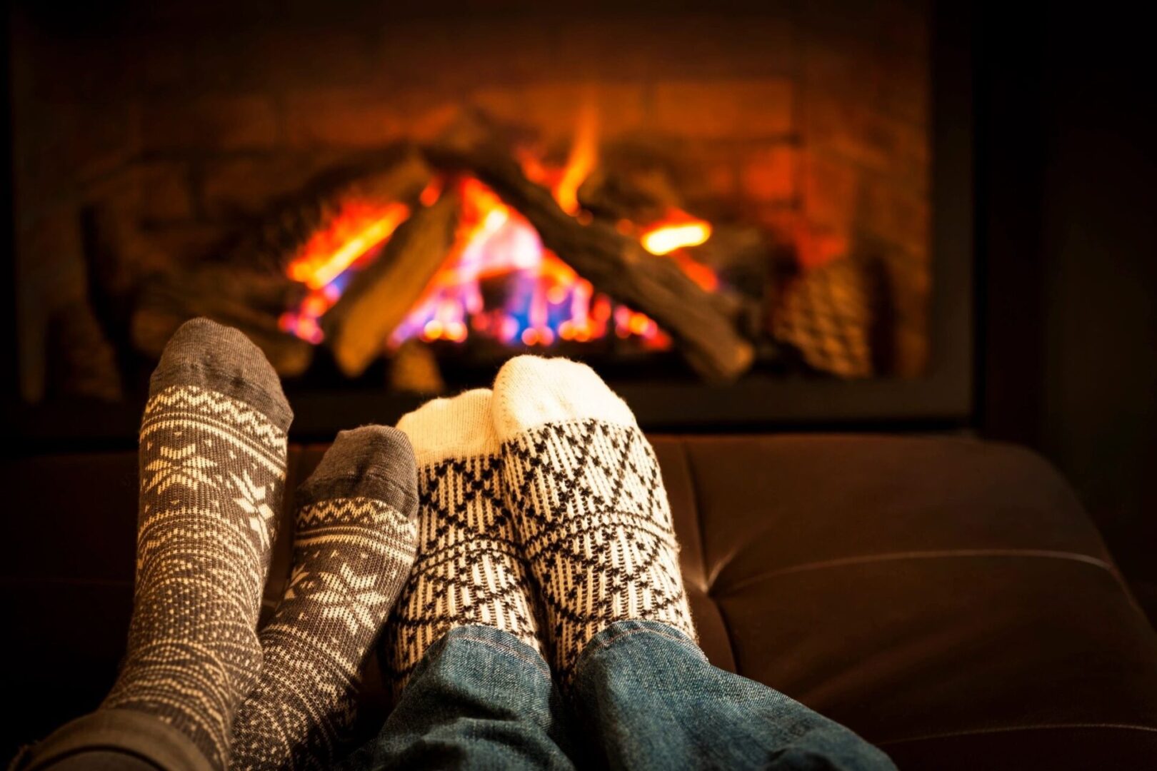 People wearing socks while sitting in front of a fireplace